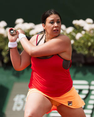 女網球運動員在紅土場上揮拍，背景有白色花朵。 — 運動 壁紙