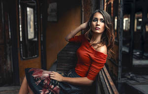 身穿紅色上衣的女性在黃昏時坐在生鏽的火車長椅上 — 模特兒 壁紙
