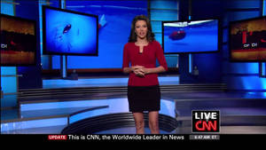 CNN新聞主播在藍色燈光的攝影棚中，螢幕上顯示著水下畫面進行現場直播。
