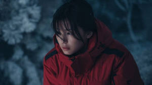 年輕女子身穿紅色冬季外套站在夜晚的雪地森林中 — 寒冷 壁紙