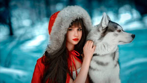 身穿紅色冬季外套的女性在雪地森林中撫摸哈士奇。 — 可愛狗狗 GIF 壁紙