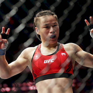 女性MMA拳手在UFC八角籠內舉手慶祝勝利。 — 運動 壁紙