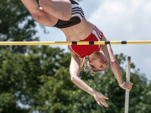 女運動員在半空中越過戶外跳高橫桿 — 運動 壁紙