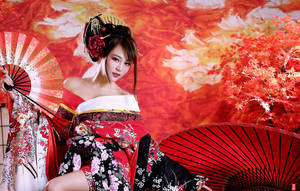 穿著傳統和服的女士手持扇子，背景是秋葉。 — 日式粉紅 壁紙