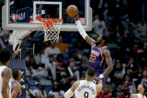 鳳凰城太陽隊球員在NBA比賽中，在防守球員附近灌籃。 — 鳳凰城太陽隊 壁紙
