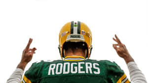 身穿包裝工裝備的足球運動員 Rodgers 高舉雙手慶祝。 — 綠灣包裝工 壁紙