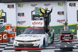 NASCAR車手在方格頒獎台上與獎盃和賽車一起慶祝勝利。 — 勝利 壁紙