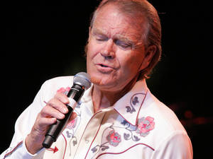 男歌手在舞台上穿著花卉襯衫 — 好萊塢 壁紙