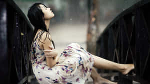 雨中坐在橋欄杆上的花卉連衣裙女子 — 女孩 壁紙