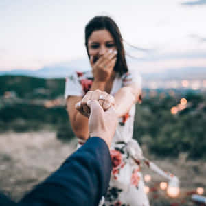 一位女性在黃昏時分的浪漫求婚中看到訂婚戒指時欣喜若狂。 — 山景 壁紙