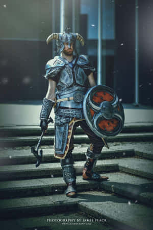 一位扮演角盔戰士的cosplayer，手持盾牌，站在積雪的石階上。 — POCO Pad 壁紙