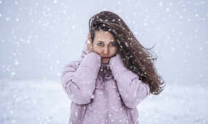 身穿紫色冬季外套的女性面對暴風雪 — 寒冷 壁紙