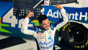 NASCAR車手在賽車旁舉起拳頭慶祝勝利。 — 大笑 壁紙