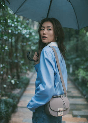 女子手持雨傘在綠色花園小徑行走 — 模特兒 壁紙