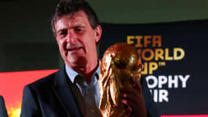 活動中穿西裝的男子手持FIFA世界盃獎盃 — 運動 壁紙