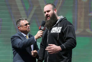 WWE記者在舞台上與摔角手Meat Castle交談。 — WWE GIF 壁紙
