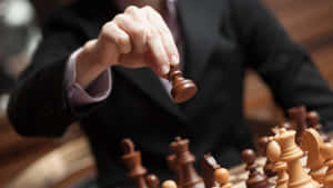 在商業策略遊戲中舉起西洋棋兵的手。 — 勝利 壁紙