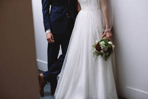 穿著婚禮服飾的新娘和新郎在室內牽手。 — 婚紗 壁紙