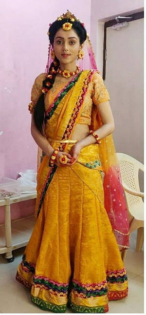 身穿華麗黃色和粉紅色印度 lehenga 並佩戴珠寶的女性，室內。 — 寶萊塢 壁紙