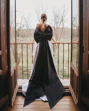 身穿黑白禮服的女士站在陽台上眺望大自然 — 婚禮 壁紙