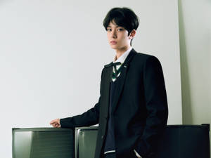 身穿校服的年輕男子在攝影棚裡靠著舊電視機。 — Enhypen 美學 壁紙