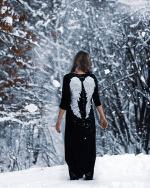 擁有天使翅膀的女性在雪地森林中行走 — 悲傷女孩 壁紙