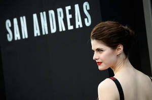 身穿黑色連衣裙、紅唇的女性在《San Andreas》電影首映會上。