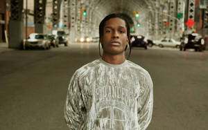 年輕男子站在橋下的城市街道上，有汽車和交通號誌。 — ASAP Rocky 壁紙
