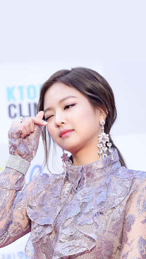 K-pop明星身穿閃爍薰衣草蕾絲服裝和吊燈耳環眨眼。 — 金範 壁紙