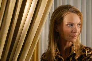 穿著豹紋襯衫的女性在金色窗簾旁若有所思地凝視。 — 女演員 壁紙