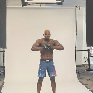 一位穿著藍色UFC短褲和手套的肌肉發達MMA戰士在工作室中擺姿勢。 — 終極格鬥冠軍賽 壁紙