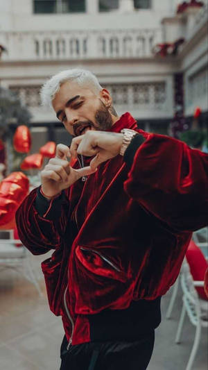 穿紅色天鵝絨外套的男士在戶外與紅色燈籠一起做出心形手勢 — 黑色愛心 GIF 壁紙