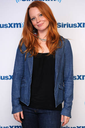 紅髮女性穿牛仔外套在SiriusXM活動中對鏡頭微笑。 — 女演員 壁紙
