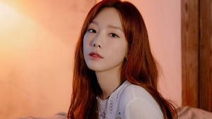 年輕紅髮女性在柔和照明的室內環境中。 — 태연 壁紙
