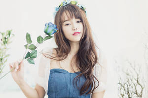戴花冠的年輕女性在柔和光線中拿著藍玫瑰。 — 玫瑰金美學 壁紙