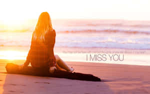 女性坐在日落沙灘上，文字I MISS YOU — 情侶擁抱 壁紙