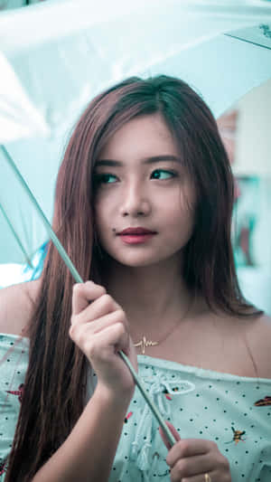 年輕女性手持藍色雨傘若有所思地望向一旁 — 香港 壁紙