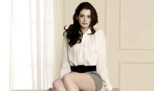 穿白色襯衫和圖案裙子的女性坐在窗邊 — 安·海瑟薇 壁紙