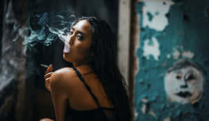 女性在昏暗的城市空間中吸煙，背景是剝落的青綠色牆壁壁畫。 — 抽菸 壁紙