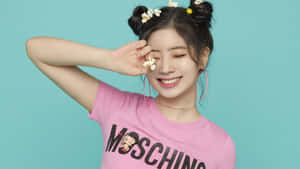 穿著粉紅色Moschino T恤的年輕女性，頭髮和手上都有爆米花，微笑著。 — 可愛風格 壁紙