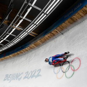 雪橇運動員在北京2022年冬奧會冰道上比賽，冰面上繪有奧運五環。 — 極限運動 壁紙