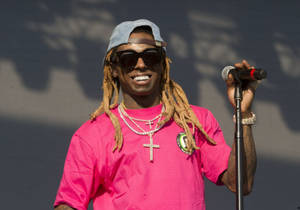 饒舌歌手 Lil Wayne 在舞台上拿著麥克風微笑。 — 小韋恩 壁紙