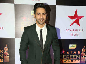 身穿深綠色西裝的男士在 Star Screen Awards 活動上微笑。 — 瓦伦·达万 壁紙
