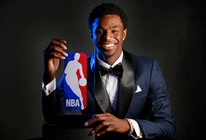 穿著燕尾服的籃球運動員面帶燦爛笑容高舉NBA獎盃。 — 酷籃球 壁紙