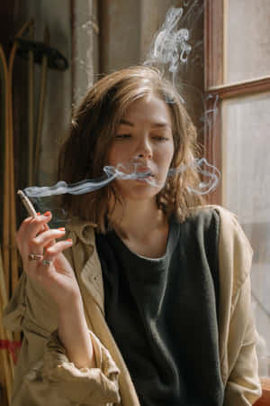 女性在室內窗邊吸煙，有陽光 — 抽菸 壁紙