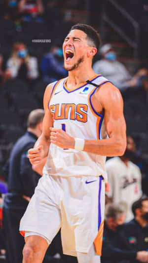 身穿太陽隊球衣的籃球運動員張開嘴巴、握緊拳頭慶祝勝利。 — Devin Booker 壁紙