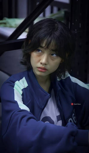 身穿藍色外套的年輕女子在昏暗的工業環境中向上凝視 — 佐助 須佐能乎 壁紙