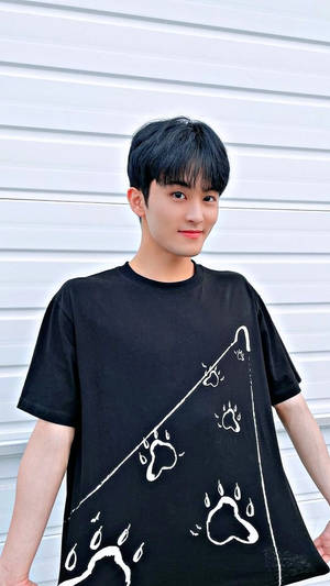 年輕男子身穿黑色T恤，上有白色爪印和雨滴圖案，在戶外微笑。 — Nct 127 壁紙