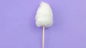 插在棍上的 fluffy 白色棉花糖，背景是紫色。 — 螢幕保護 壁紙