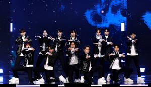 K-pop團體穿著黑白服裝在星光舞台上跳舞。 — 寶藏 壁紙